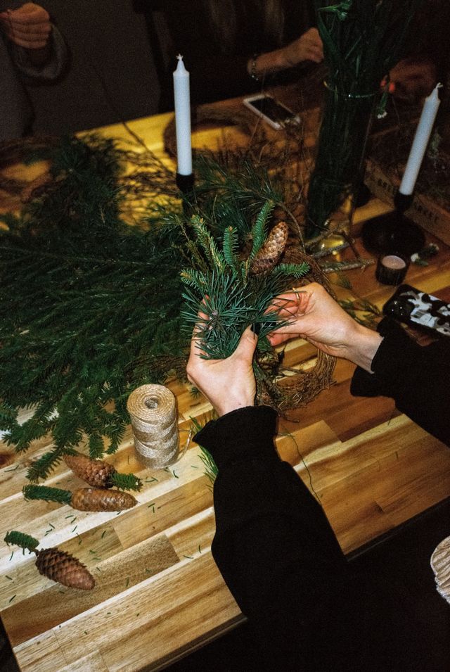 DIY Christmas wreath making materials including ribbon, pinecones and dried orange slices