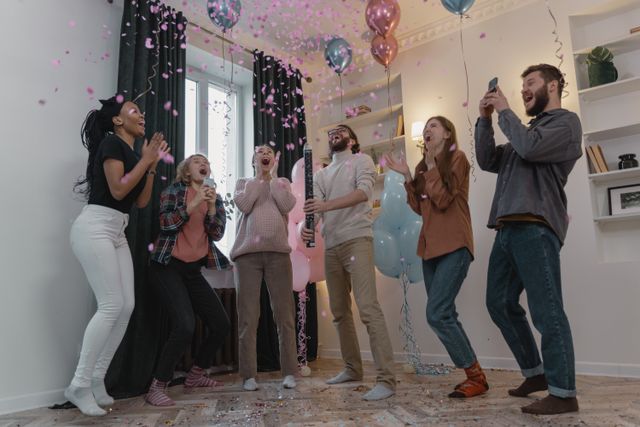 Balloon reveal with pink confetti and balloon garland backdrop at a Bristol gender reveal party