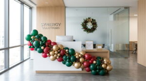 Office reception styled with festive balloon garland and lighting for Christmas Jumper Day 2026 in Bristol