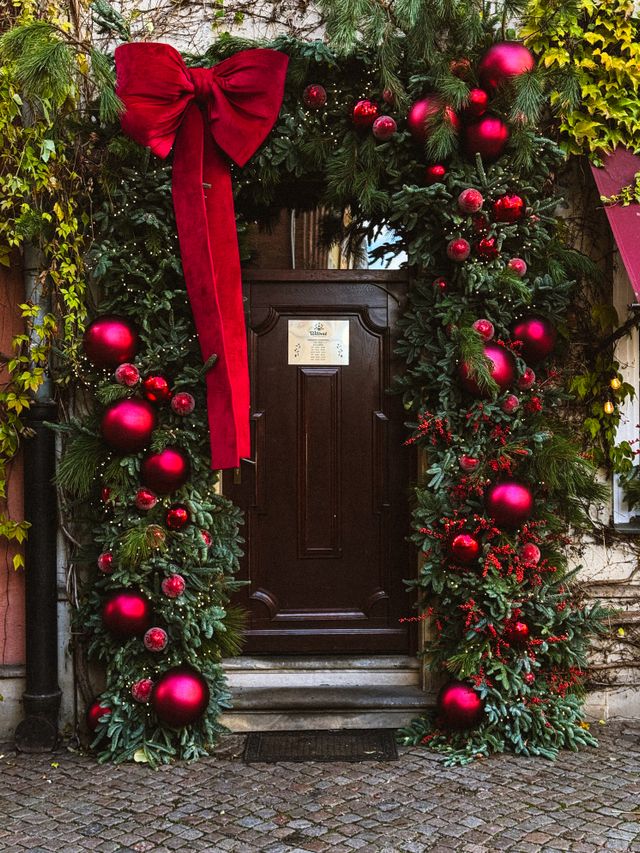 Christmas wreath and entrance garland styled in a matching burgundy and gold palette in Bristol